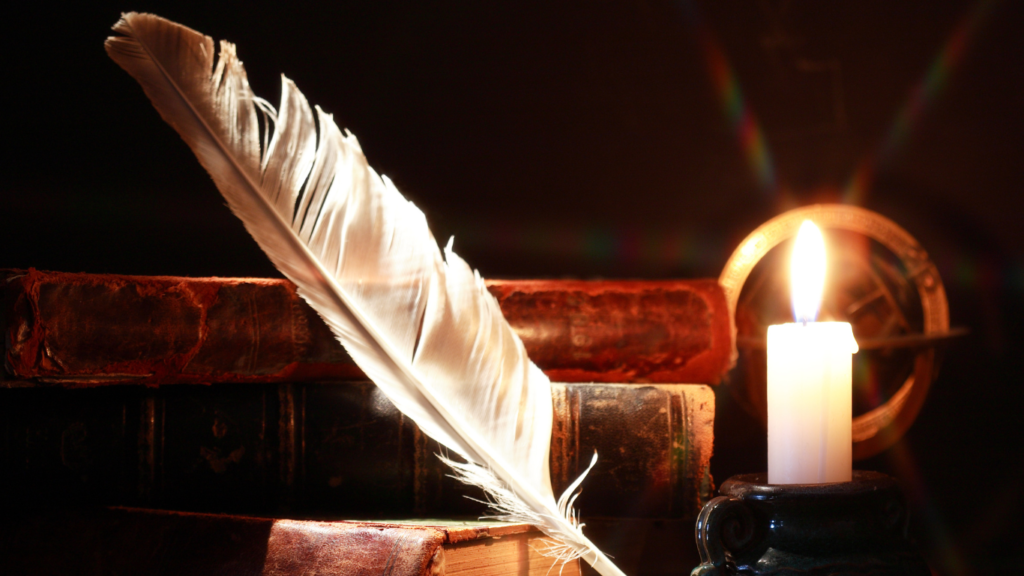 Old world books, a feather pen and a candle.
